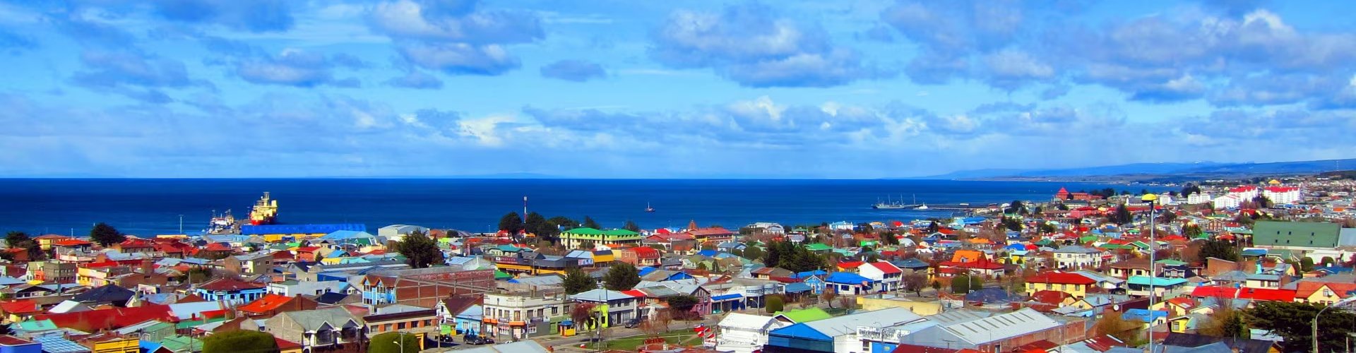 Luxury car parked overlooking Punta Arenas at sunset